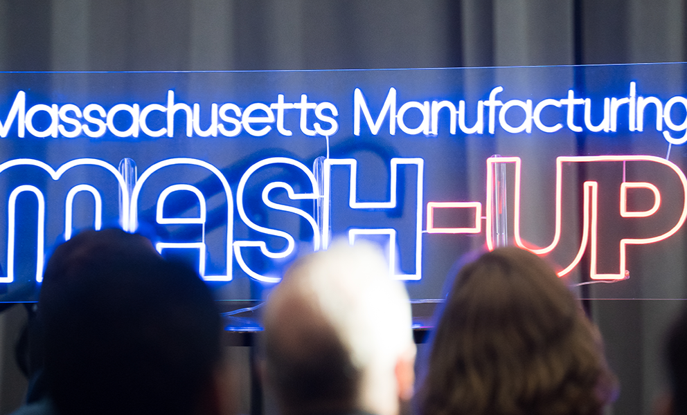 2025 Mash-Up neon sign on stage with audience in the front row